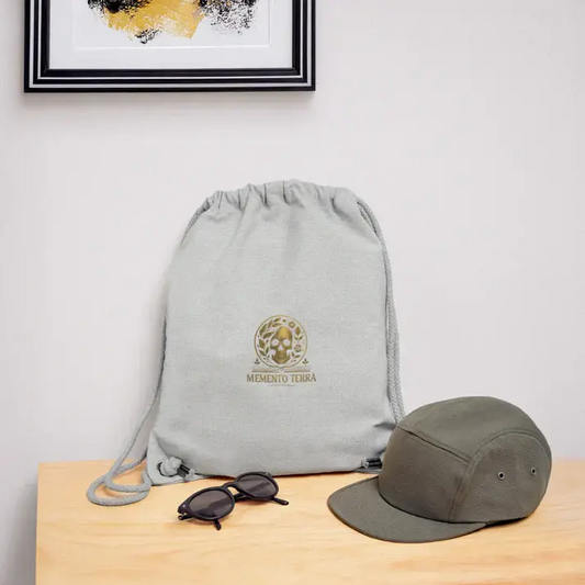 Sac à dos en tissu Memento Terra aux côtés d’accessoires, illustrant un design engagé qui raconte une histoire.